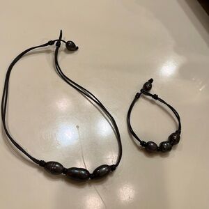 Matching black pearl bracelet and necklace with leather.